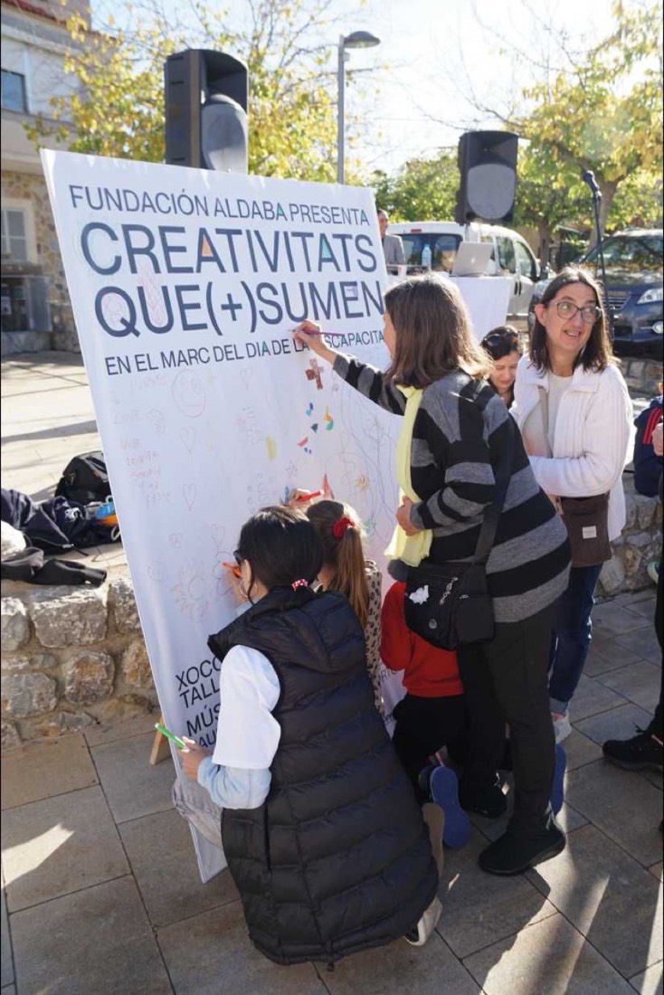 Infants pintant el mural de Creativitats que (+) sumen