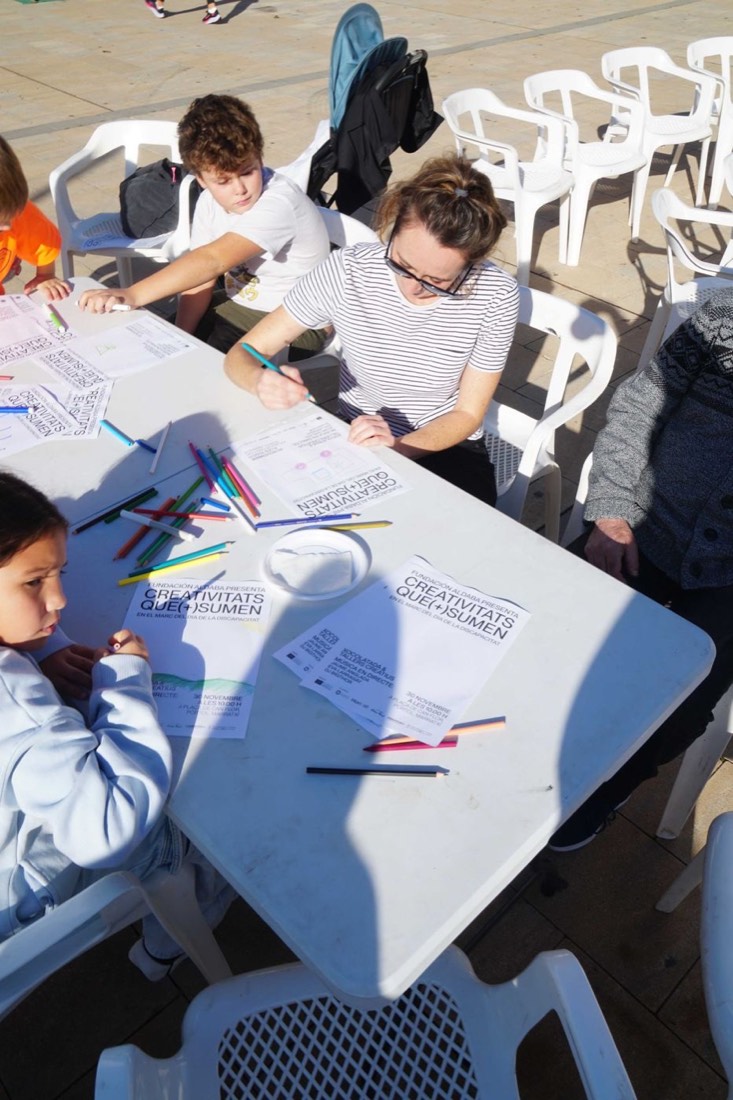 Infants i famílies dibuixant a les taules dels tallers creatius